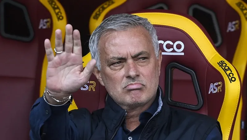 José Mourinho acenando com a mão sentado no banco de reservas da Roma